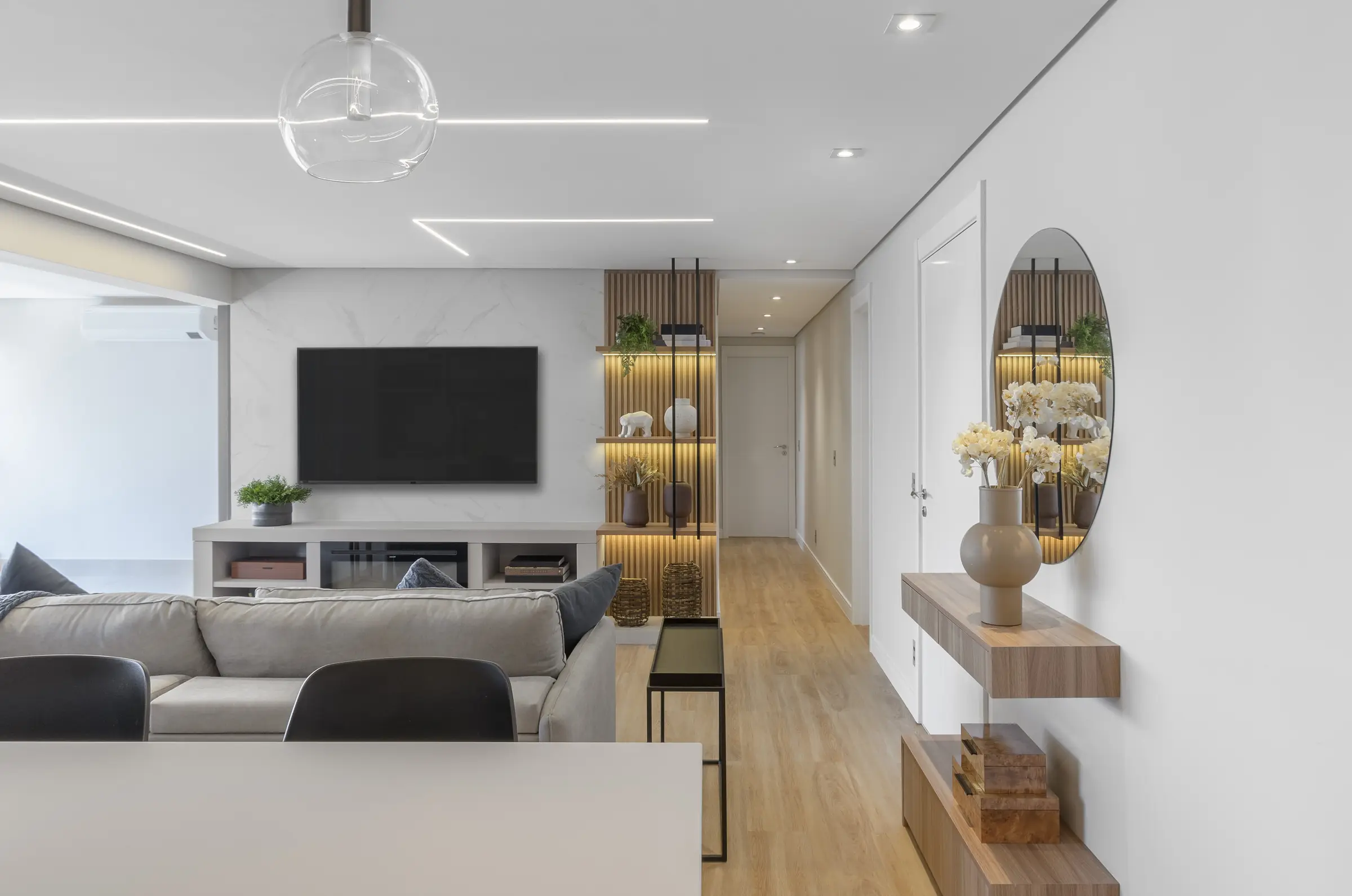 Living de apartamento de alto padrão entregue pela MS Engenharia, com marcenaria planejada, iluminação linear e ambientes integrados