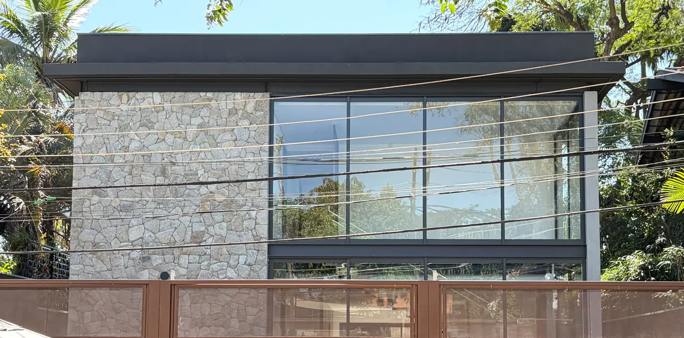 Fachada nova em pedra e vidro da casa construída do zero