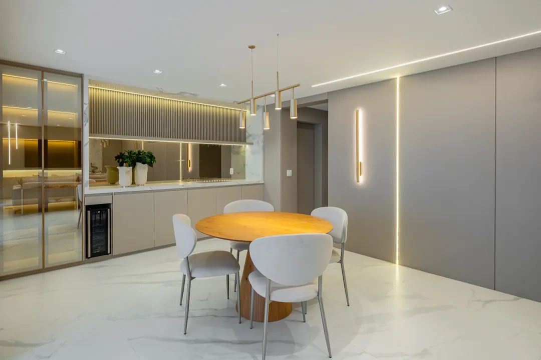 Sala de jantar com mesa redonda, cristaleira iluminada e perfil de LED na parede